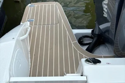 Slide: The Image of 2023 Edgewater 230 CX boat deck with striped flooring and Yamaha engine. - 5