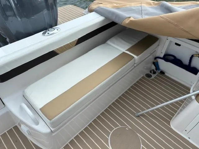 Slide: The Image of 2023 Edgewater 230 CX boat interior with cushioned seating and striped flooring. - 6