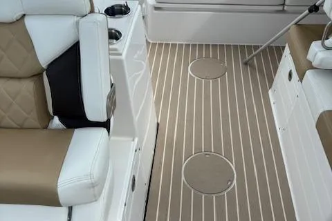 Slide: The Image of 2023 Edgewater 230 CX boat interior with cushioned seating and striped flooring. - 7