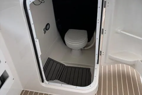 Slide: The Image of 2023 Edgewater 230 CX boat interior with compact marine toilet. - 9