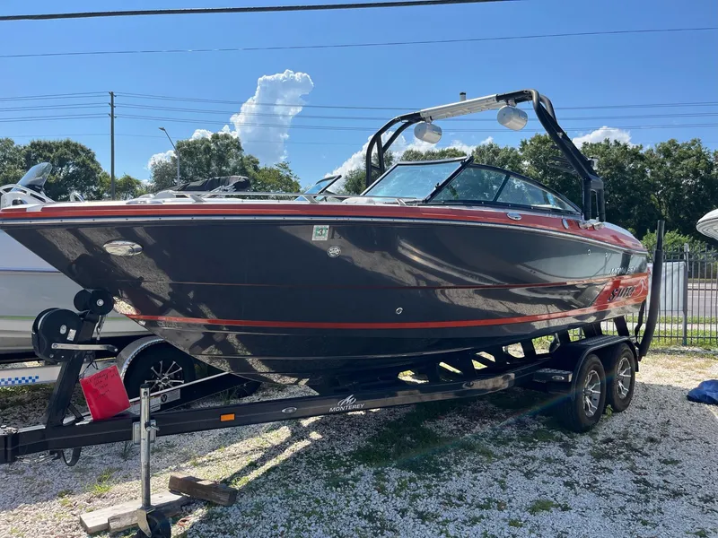Slide: The Image of 2018 Monterey 238 Surf boat on trailer, parked outdoors under clear sky. - 1