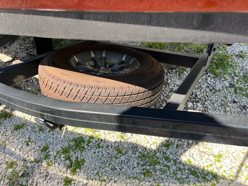 Slide: The Image of Spare tire on a 2018 Monterey 238 Surf trailer, resting on gravel. - 4