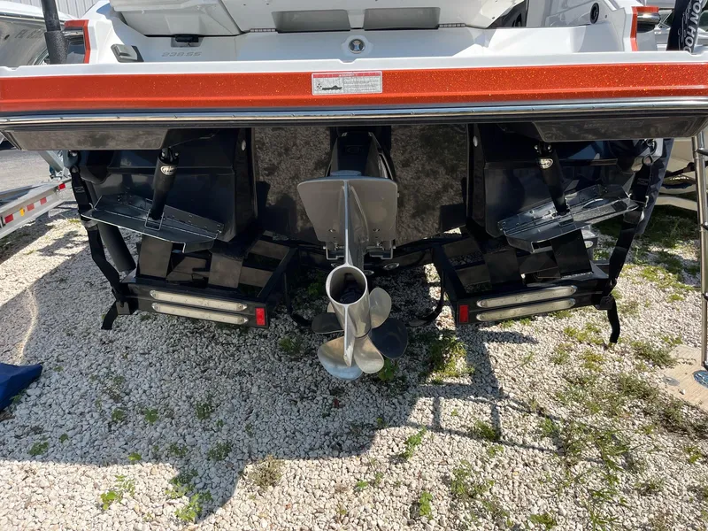 Slide: The Image of 2018 Monterey 238 Surf boat stern with dual propellers on gravel surface. - 5