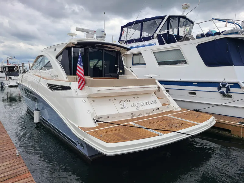 Slide: The Image of 2014 Sea Ray 510 Sundancer yacht docked, featuring sleek design and American flag. - 2