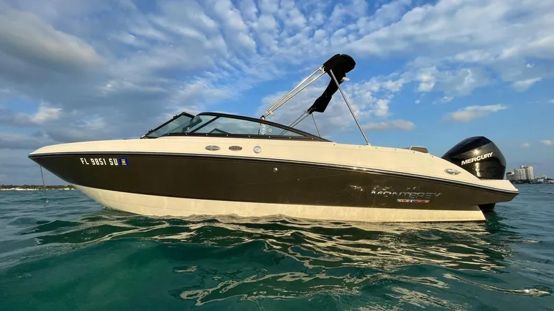 Slide: The Image of 2021 Monterey M225 boat on water under blue sky. - 1