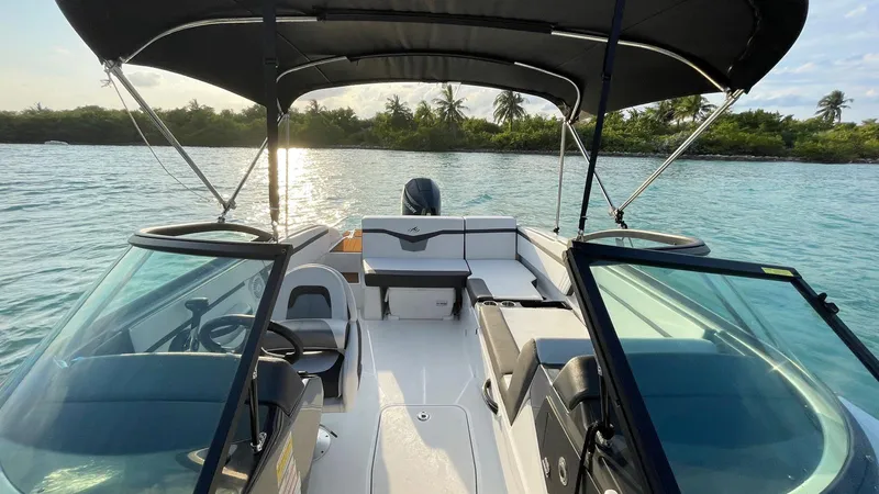 Slide: The Image of 2021 Monterey M225 boat interior on calm water with lush shoreline. - 7