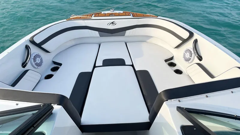 Slide: The Image of 2021 Monterey M225 boat interior with white and black seating, on blue water. - 8