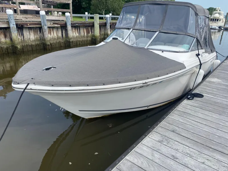Slide: The Image of 2020 Sea Fox 226 Traveler boat docked with protective cover, calm water background. - 14