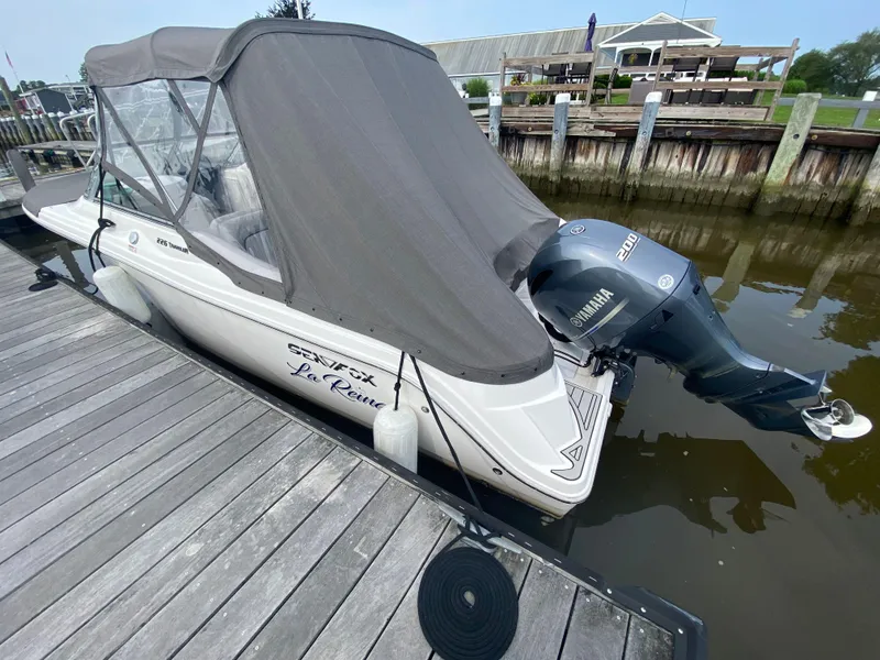 Slide: The Image of 2020 Sea Fox 226 Traveler boat docked with Yamaha outboard motor, covered in gray canvas. - 16