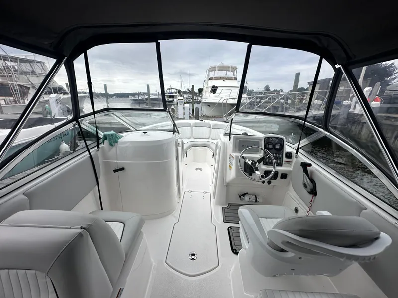 Slide: The Image of 2020 Sea Fox 226 Traveler boat interior with helm, seating, and marina view. - 9