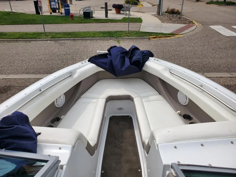 Slide: The Image of 2007 Cobalt 240 boat interior with white seating and blue covers. - 13