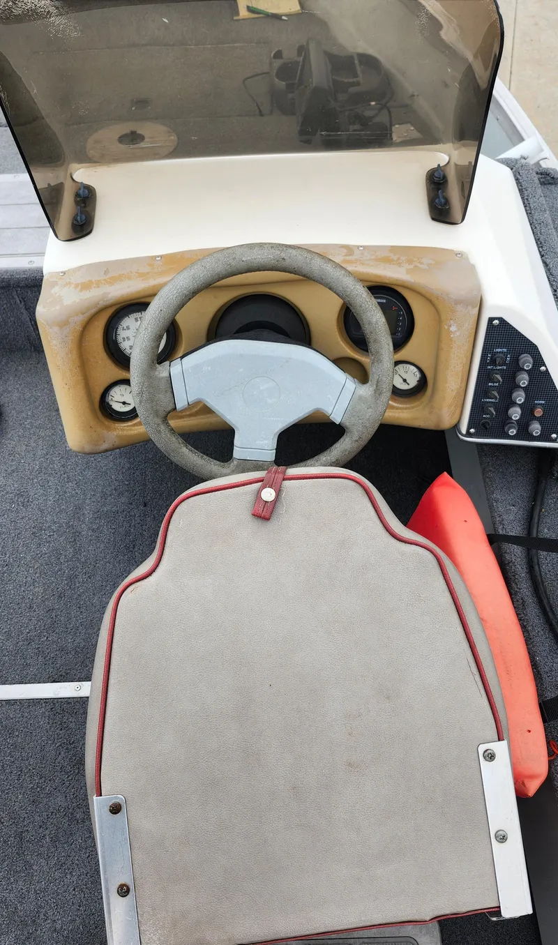 Slide: The Image of 1995 MirroCraft GUIDE IMPACT 16 V boat dashboard with steering wheel and controls. - 9
