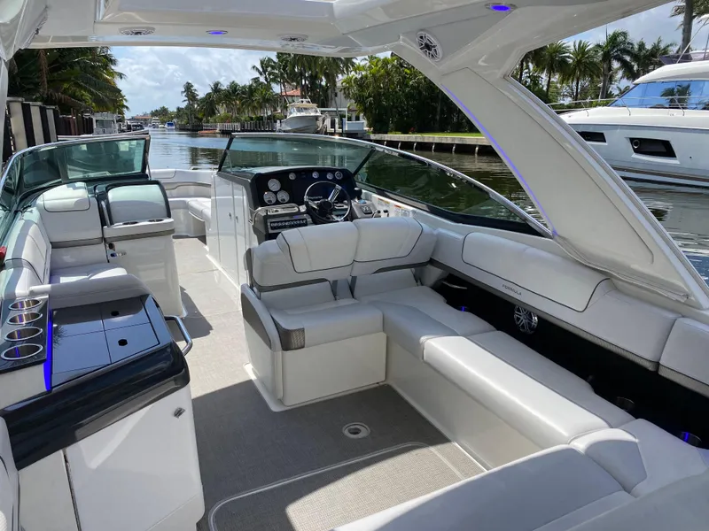 Slide: The Image of 2021 Formula 310 Bowrider I/O with luxurious seating and sleek design on a sunny waterway. - 16