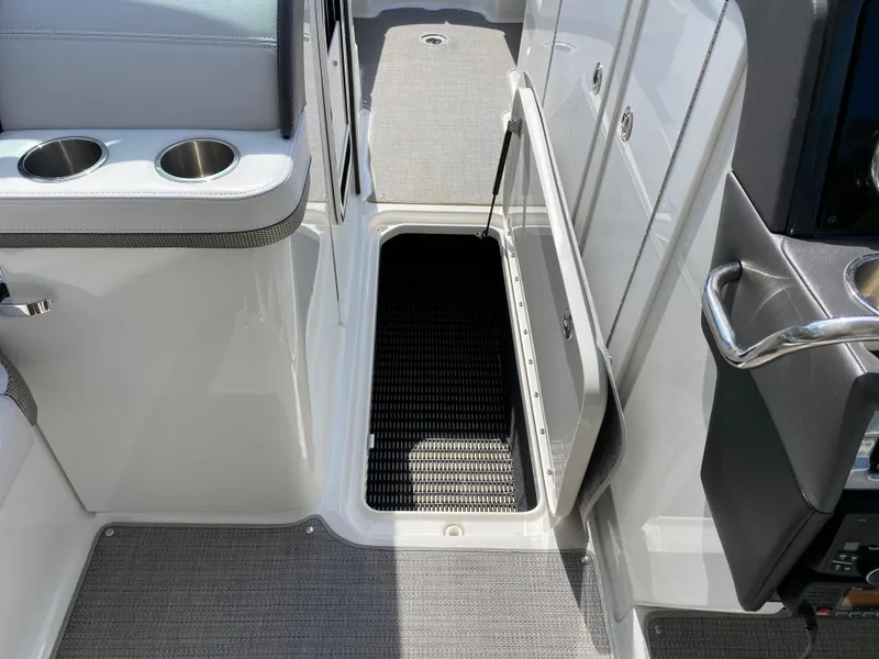 Slide: The Image of 2021 Formula 310 Bowrider I/O interior with open storage compartment and cup holders. - 35