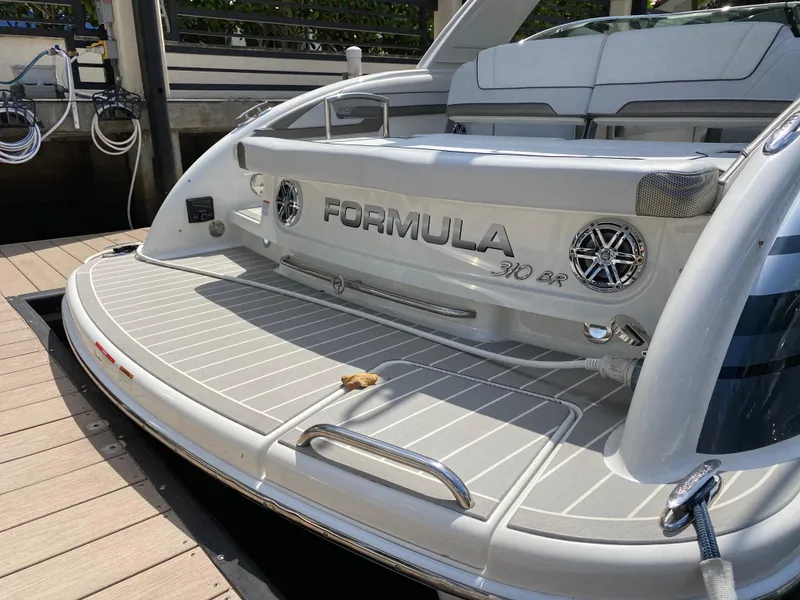 Slide: The Image of 2021 Formula 310 Bowrider I/O boat at dock, featuring spacious deck and sleek design. - 6