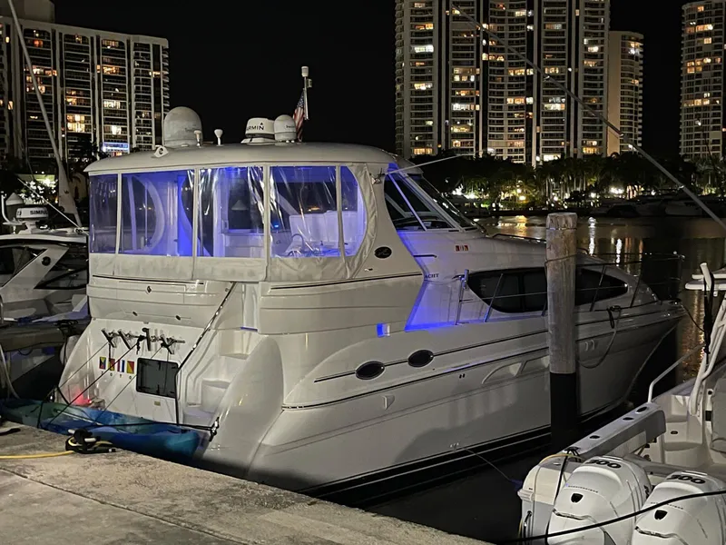 Slide: The Image of 2003 Sea Ray 390 Motor Yacht docked at night with city lights in background. - 11