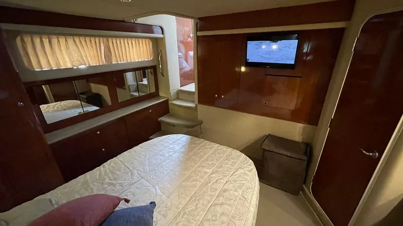 Slide: The Image of Luxurious 2003 Sea Ray 390 Motor Yacht bedroom with TV and elegant wood finishes. - 4