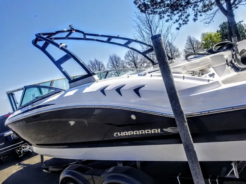 Slide: The Image of 2016 Chaparral 21 H2O Sport boat with sleek black and white design on trailer. - 19