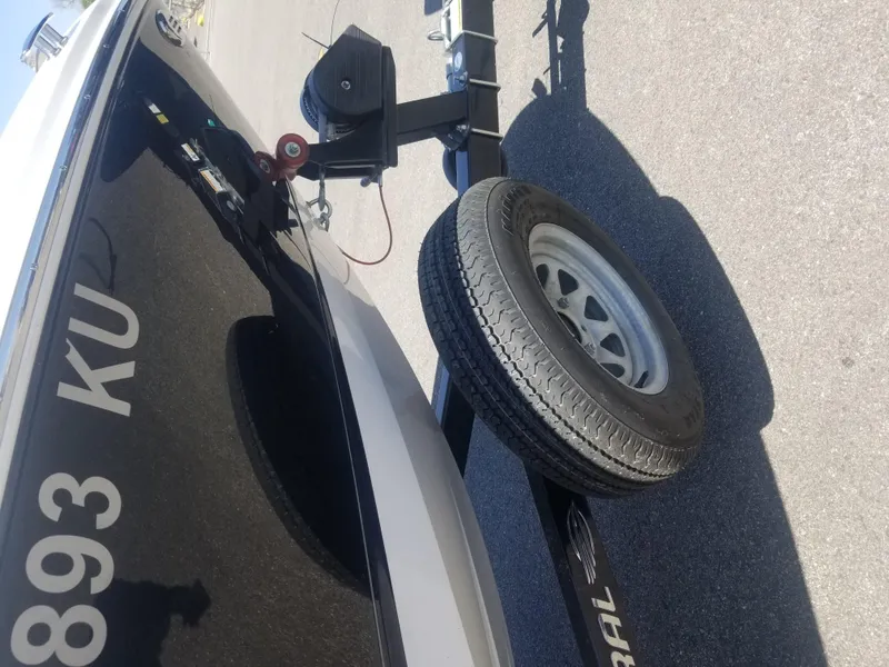 Slide: The Image of 2016 Chaparral 21 H2O Sport boat on trailer, close-up view of wheel and hull. - 24