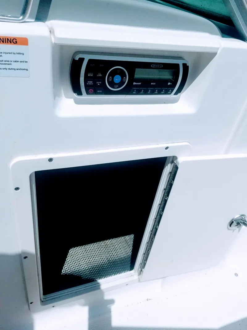 Slide: The Image of 2016 Chaparral 21 H2O Sport boat interior with stereo system and storage compartment. - 29