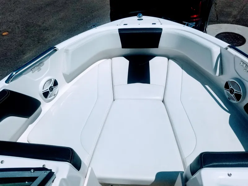 Slide: The Image of 2016 Chaparral 21 H2O Sport boat interior with white seating and speakers. - 6