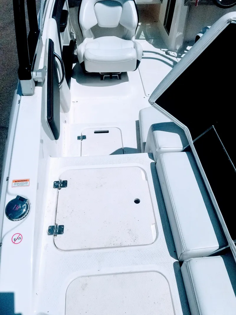 Slide: The Image of 2016 Chaparral 21 H2O Sport boat interior with white seating and storage compartments. - 7