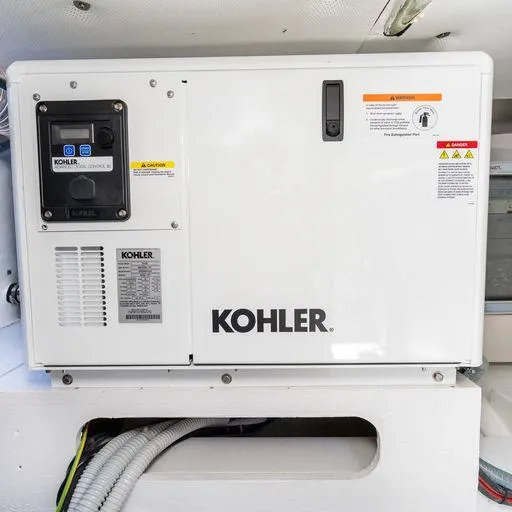 Slide: The Image of Kohler generator on 2023 Solaris Power 40 Open yacht, featuring control panel and safety labels. - 35