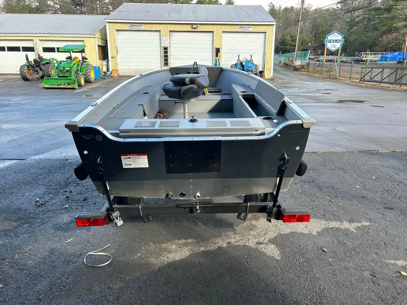 Slide: The Image of 2025 Lund Fury 1400 Tiller boat in a parking lot, rear view. - 2