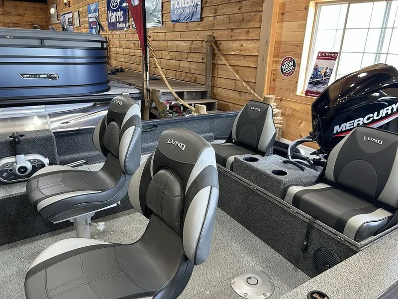 Slide: The Image of 2025 Lund Rebel XL 1650 XL SS boat interior with Mercury engine in a wooden garage. - 3