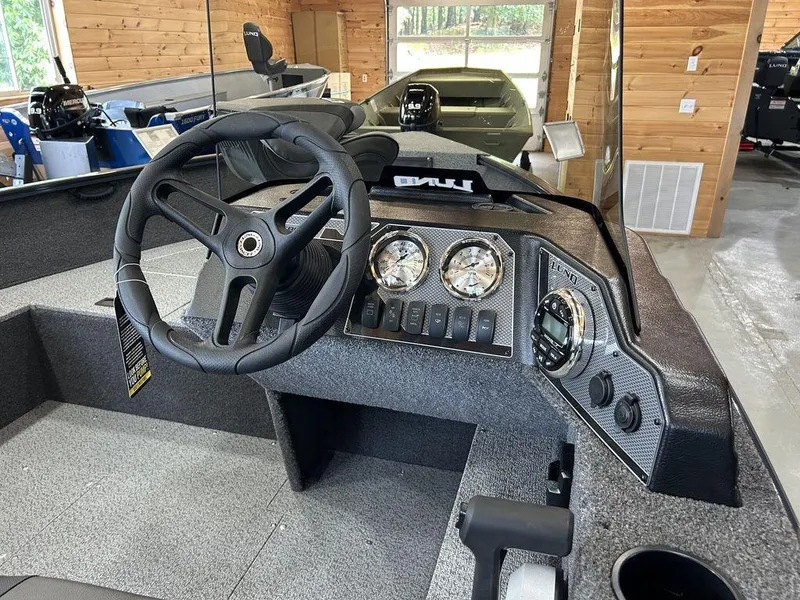 Slide: The Image of 2025 Lund Rebel XL 1650 XL SS boat interior with steering wheel and dashboard controls. - 4
