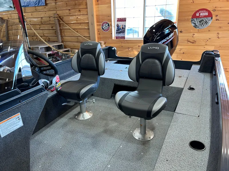 Slide: The Image of 2025 Lund Rebel XL 1650 XL SS boat interior with two seats and a Mercury engine. - 9