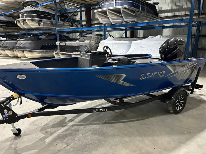 Slide: The Image of 2025 Lund ADVENTURE 1675 SS boat in storage, blue exterior, on a trailer. - 3