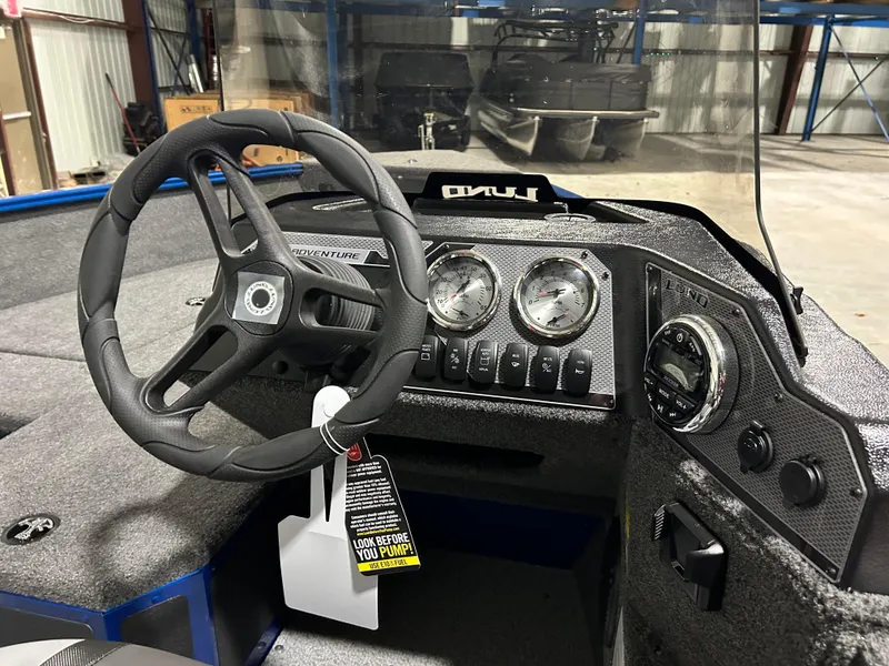 Slide: The Image of 2025 Lund ADVENTURE 1675 SS boat dashboard with steering wheel and instrument panel. - 7