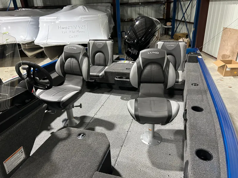 Slide: The Image of 2025 Lund ADVENTURE 1675 SS boat interior with gray seating and steering wheel. - 8