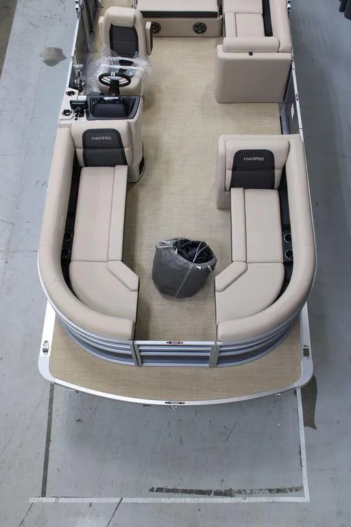 Slide: The Image of 2025 Harris CRUISER 230 SL pontoon boat interior with beige seating and steering console. - 3