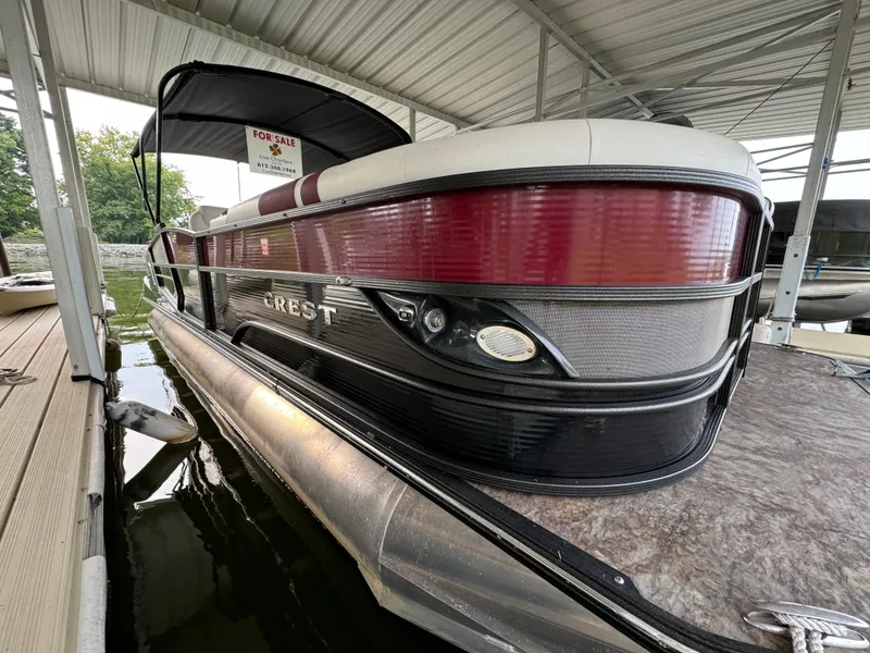Slide: The Image of 2019 Crest Caribbean 250 SLRC pontoon boat docked under a covered slip. - 12