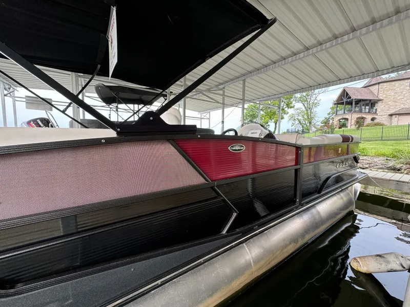 Slide: The Image of 2019 Crest Caribbean 250 SLRC pontoon boat docked under a covered structure. - 4