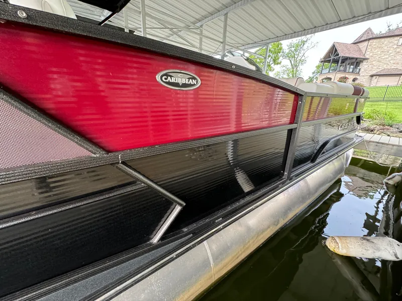Slide: The Image of 2019 Crest Caribbean 250 SLRC pontoon boat docked under a canopy. - 5