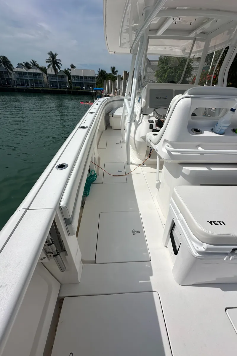 Slide: The Image of 2015 Intrepid 400 Center Console boat, sleek design, docked by waterfront homes. - 15