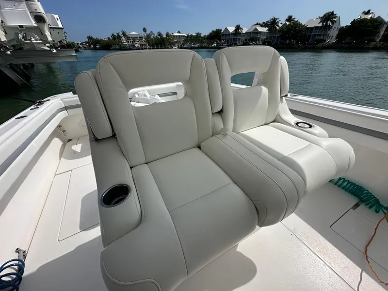 Slide: The Image of Luxurious seating on a 2015 Intrepid 400 Center Console boat, docked by the water. - 8
