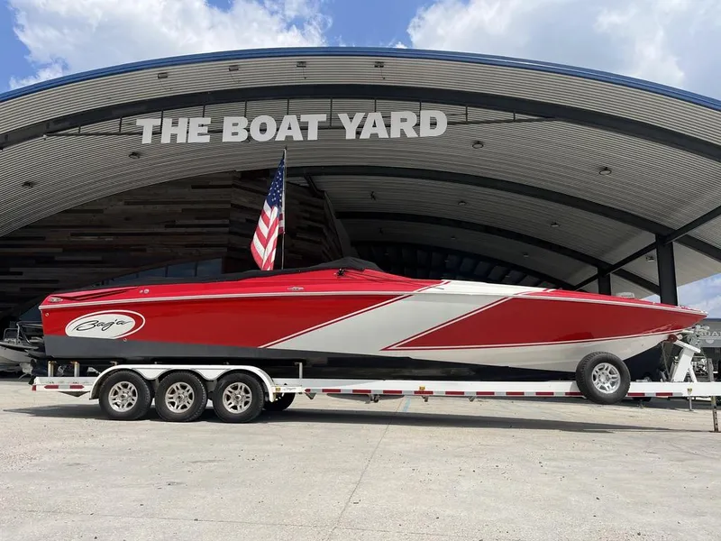 Slide: The Image of 2013 Baja 35 Outlaw boat on trailer at The Boat Yard, red and white design. - 13