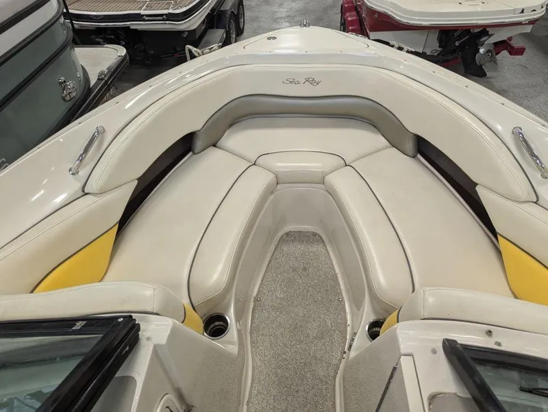 Slide: The Image of 2005 Sea Ray 240 SEL boat interior with beige seating and carpeted floor. - 5