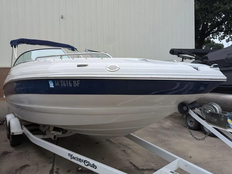 Slide: The Image of 2009 Crownline 240 LS boat on trailer, parked outdoors. - 2