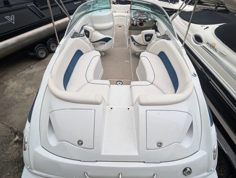 Slide: The Image of 2009 Crownline 240 LS boat interior with white and blue seating, docked beside other boats. - 5