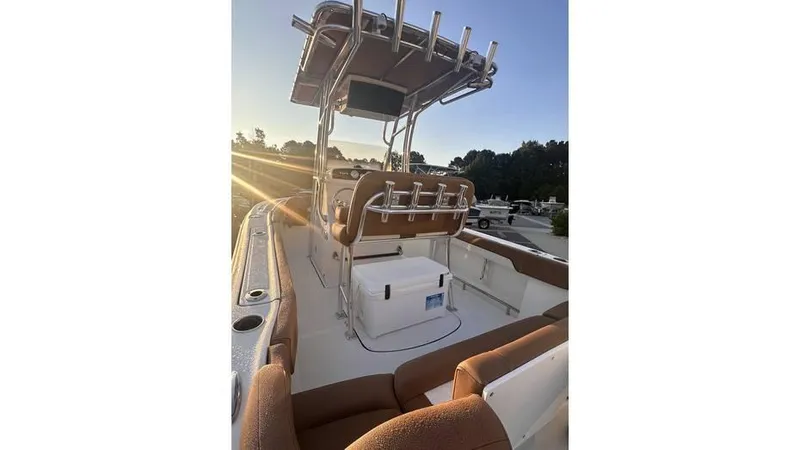 Slide: The Image of 2025 Pioneer 202 Islander boat interior with seating and console at sunset. - 8