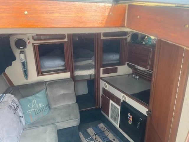 Slide: The Image of Interior of 1988 Regal 277 Commodore XL boat with cozy seating and compact kitchen area. - 16