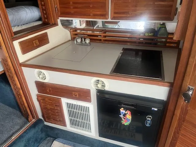 Slide: The Image of 1988 Regal 277 Commodore XL boat kitchen with stove, sink, and wooden cabinets. - 19