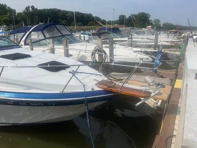 Slide: The Image of 1988 Regal 277 Commodore XL docked at a marina, surrounded by other boats. - 2