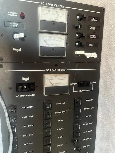 Slide: The Image of Control panel of a 1988 Regal 277 Commodore XL boat, featuring AC and DC load centers. - 21