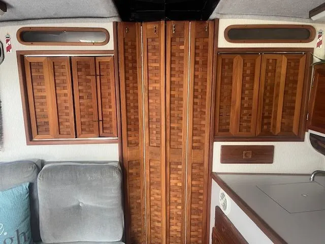 Slide: The Image of Interior of 1988 Regal 277 Commodore XL with wooden cabinets and cozy seating. - 22